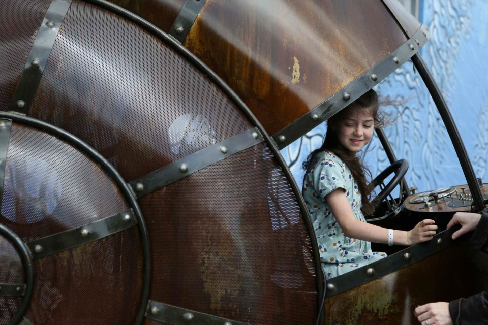 Zolie, 8, takes her parent's snail car out for a pretend ride at Sarriugarte and Mate's metal working shop in Oakland, Calif., on Sunday, March 22, 2015.